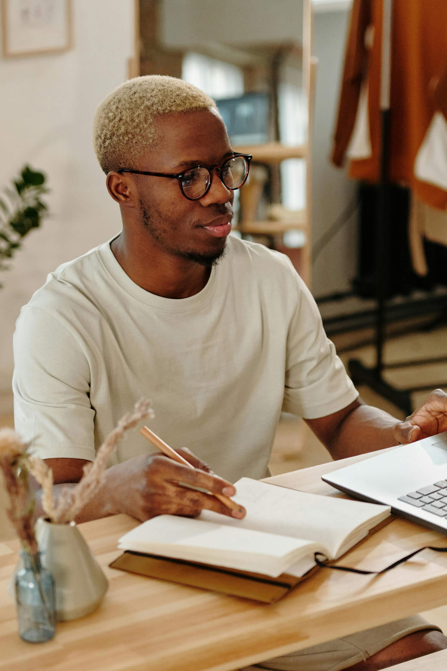 Smiling man journaling with laptop